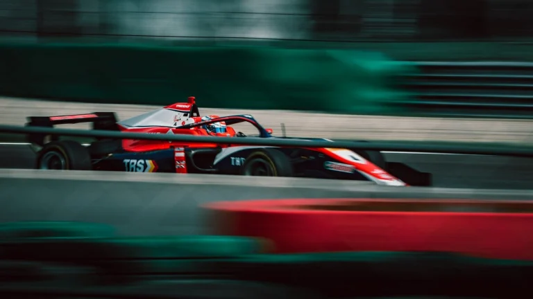 a man driving a race car on a track