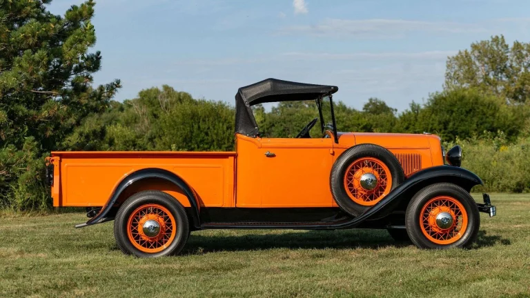 Golden Orange 1933 Ford V8 Roadster Pickup shown in side profile on a grassy lawn