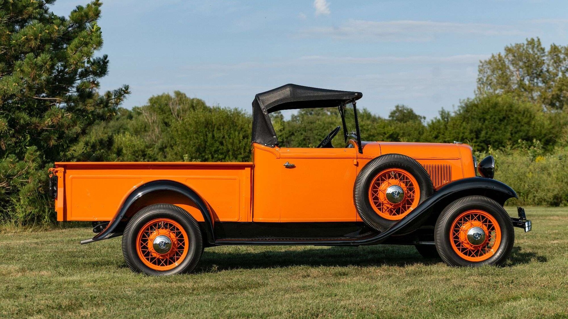 Golden Orange 1933 Ford V8 Roadster Pickup shown in side profile on a grassy lawn