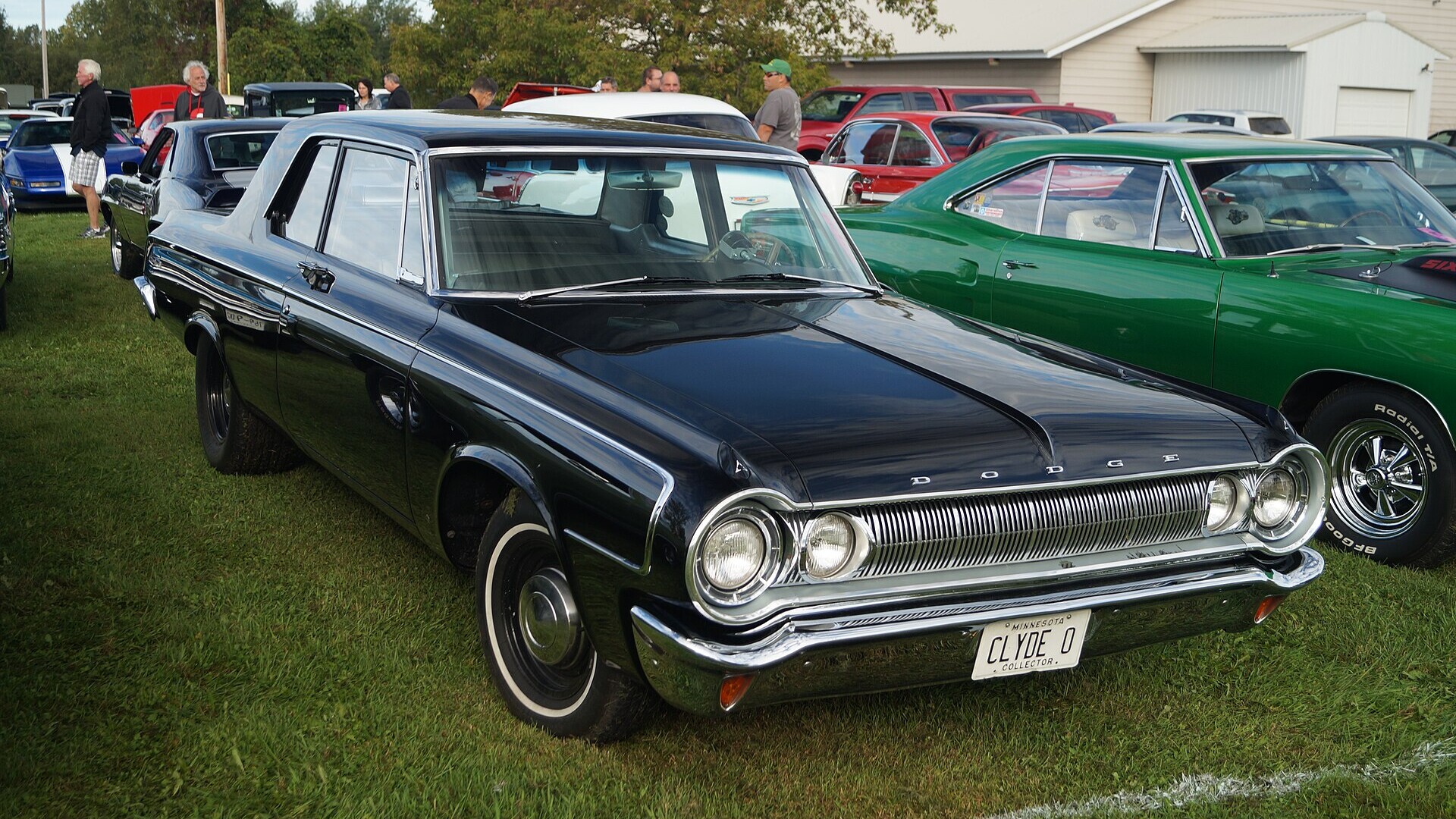A black 1964 Dodge 330 sedan at a car show