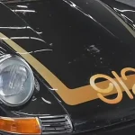 Black 1969 Porsche with gold 912 hood graphic and gold stripes after detailing