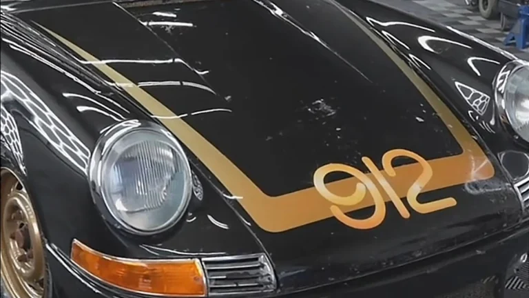 Black 1969 Porsche with gold 912 hood graphic and gold stripes after detailing