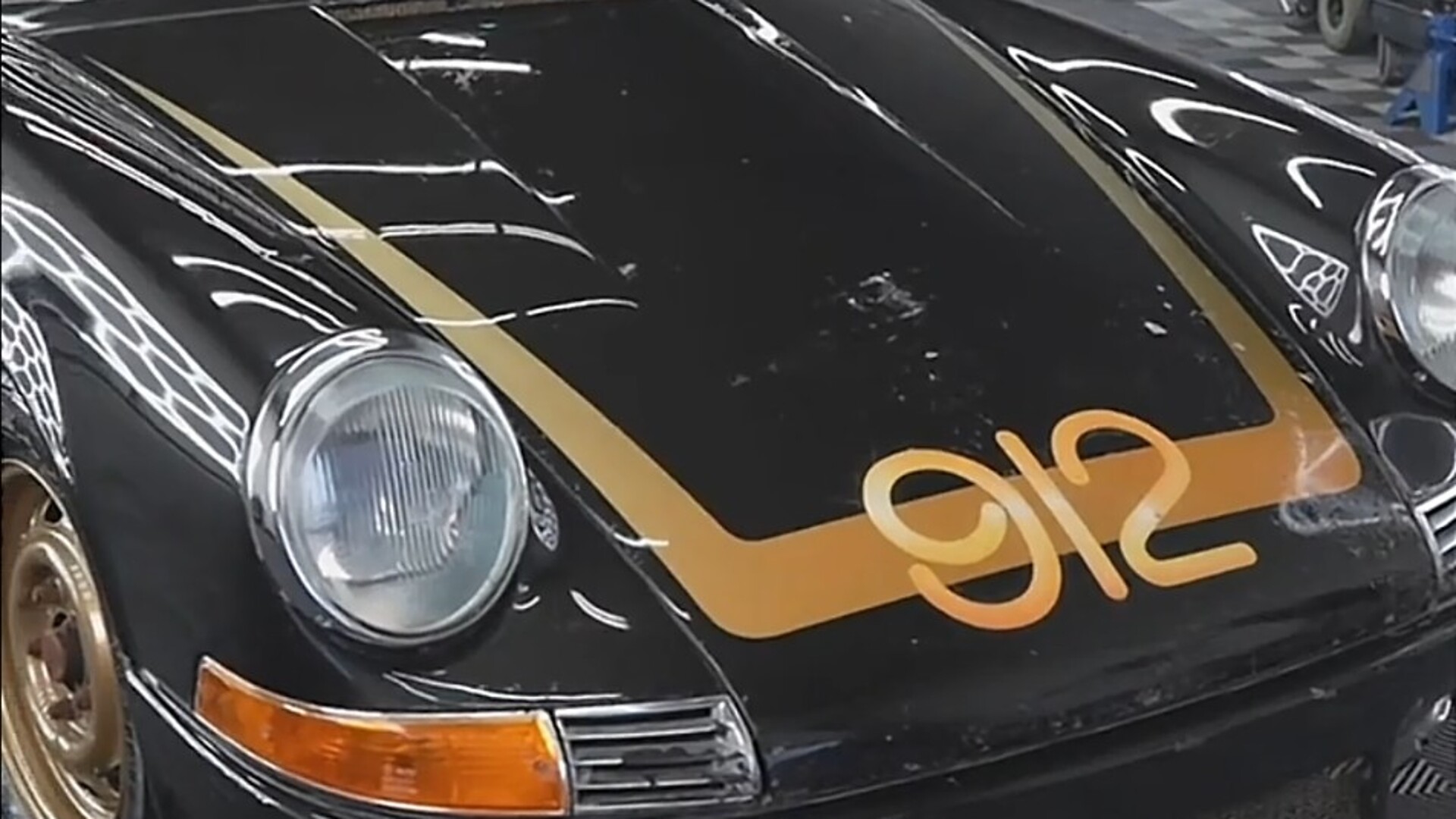 Black 1969 Porsche with gold 912 hood graphic and gold stripes after detailing