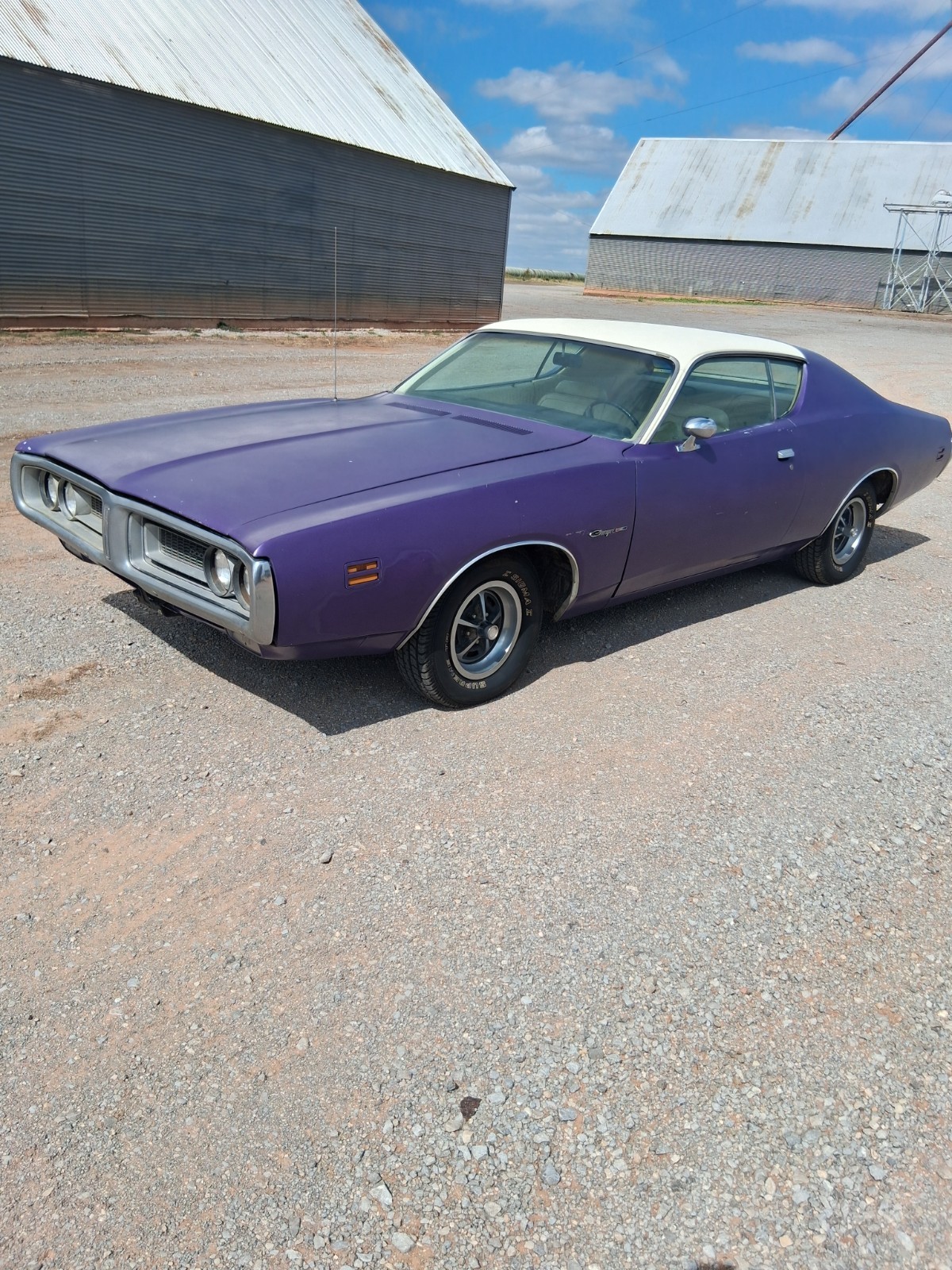 Purple 1971 Dodge Charger hardtop with white vinyl roof parked on gravel in Oklahoma