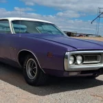 Plum Crazy purple 1971 Dodge Charger with white vinyl roof parked on gravel in Oklahoma