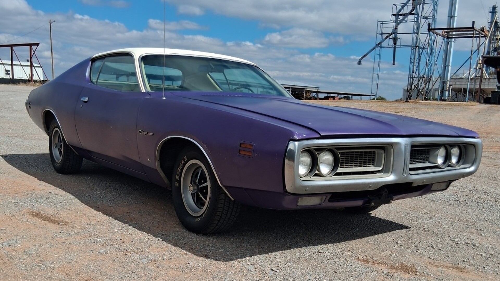 Plum Crazy purple 1971 Dodge Charger with white vinyl roof parked on gravel in Oklahoma