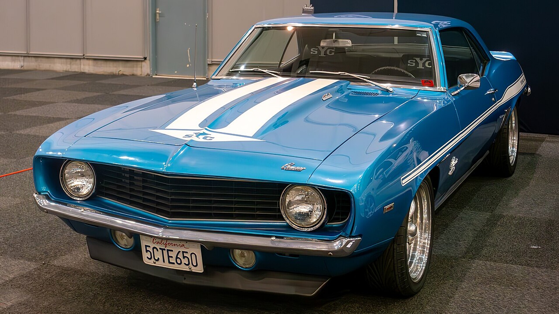 Blue 1969 Chevrolet Camaro with white stripes displayed as the 2 Fast 2 Furious Yenko at the 2024 Brussels Motor Show
