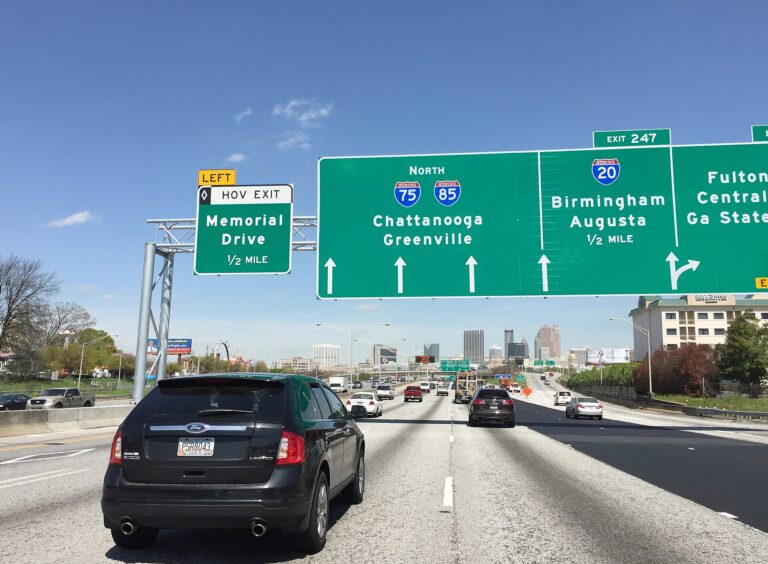 Traffic on the Downtown Connector in Atlanta beneath green overhead highway signs