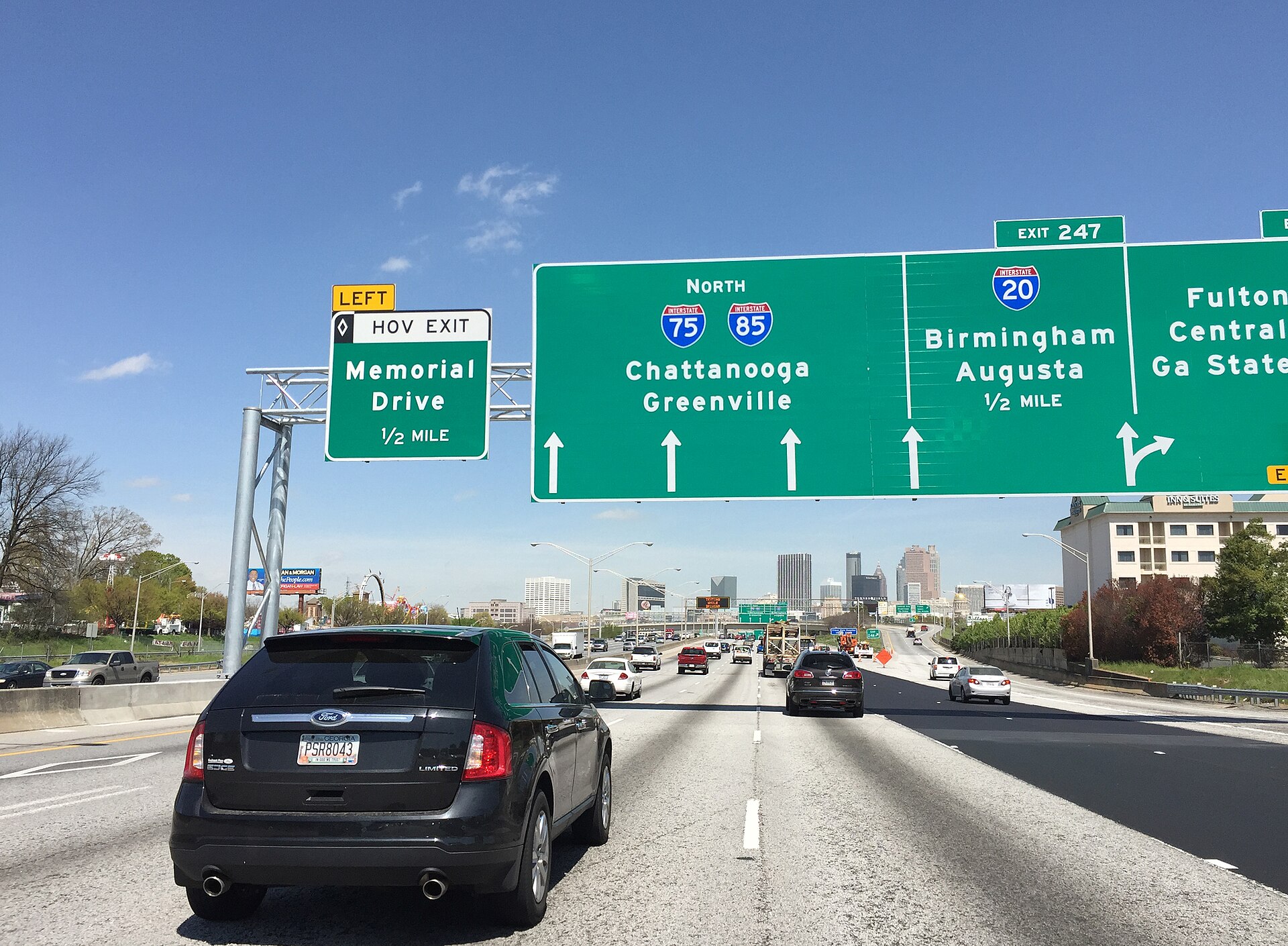 Traffic on the Downtown Connector in Atlanta beneath green overhead highway signs