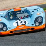a blue and orange race car driving on a race track