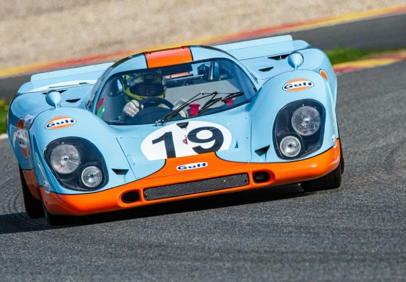 a blue and orange race car driving on a race track