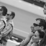 Young Brexton Busch sits on Kyle Busch's shoulders beside Samantha Busch at Michigan International Speedway in 2019