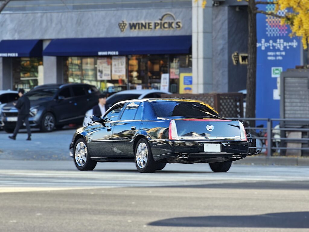 A black Cadillac DTS Platinum sedan parked on a city street