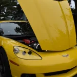 Yellow C6-generation Chevrolet Corvette coupe with its hood open