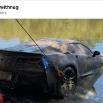 Mud-covered C7 Corvette Grand Sport on a tow cable at the edge of a Georgia river