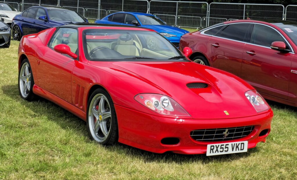 A red Ferrari 575 Superamerica parked on grass