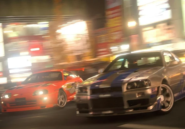 two cars driving down a city street at night