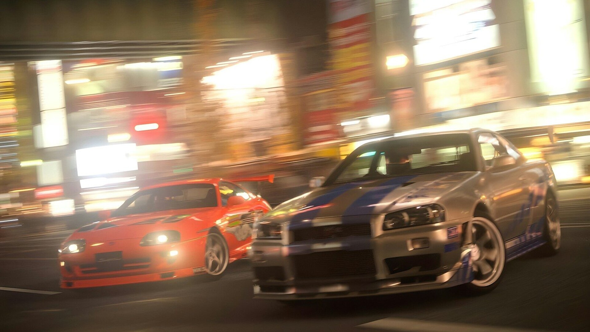 two cars driving down a city street at night