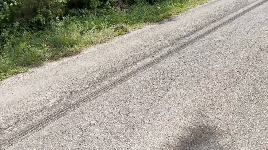 Black tire marks from the Hemibago burnout on a rural road