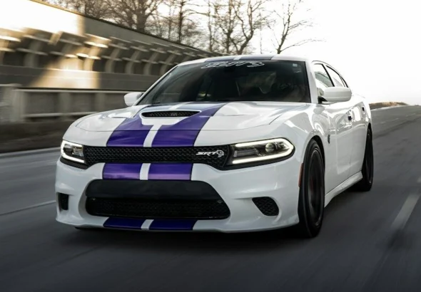 White car with purple stripes driving on road