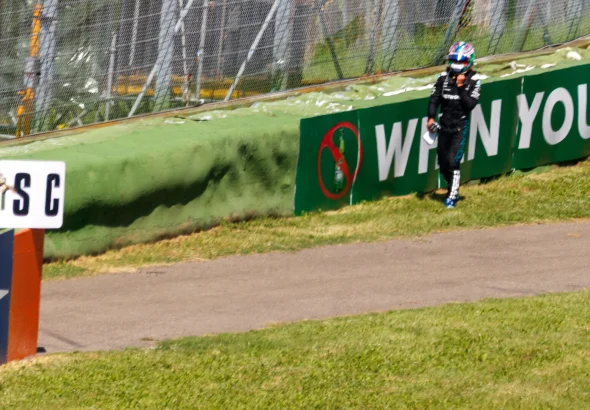 Kimi Antonelli walking along the barrier after retiring from the 2025 Emilia Romagna Grand Prix at Imola