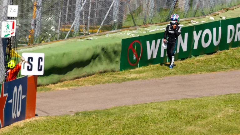 Kimi Antonelli walking along the barrier after retiring from the 2025 Emilia Romagna Grand Prix at Imola
