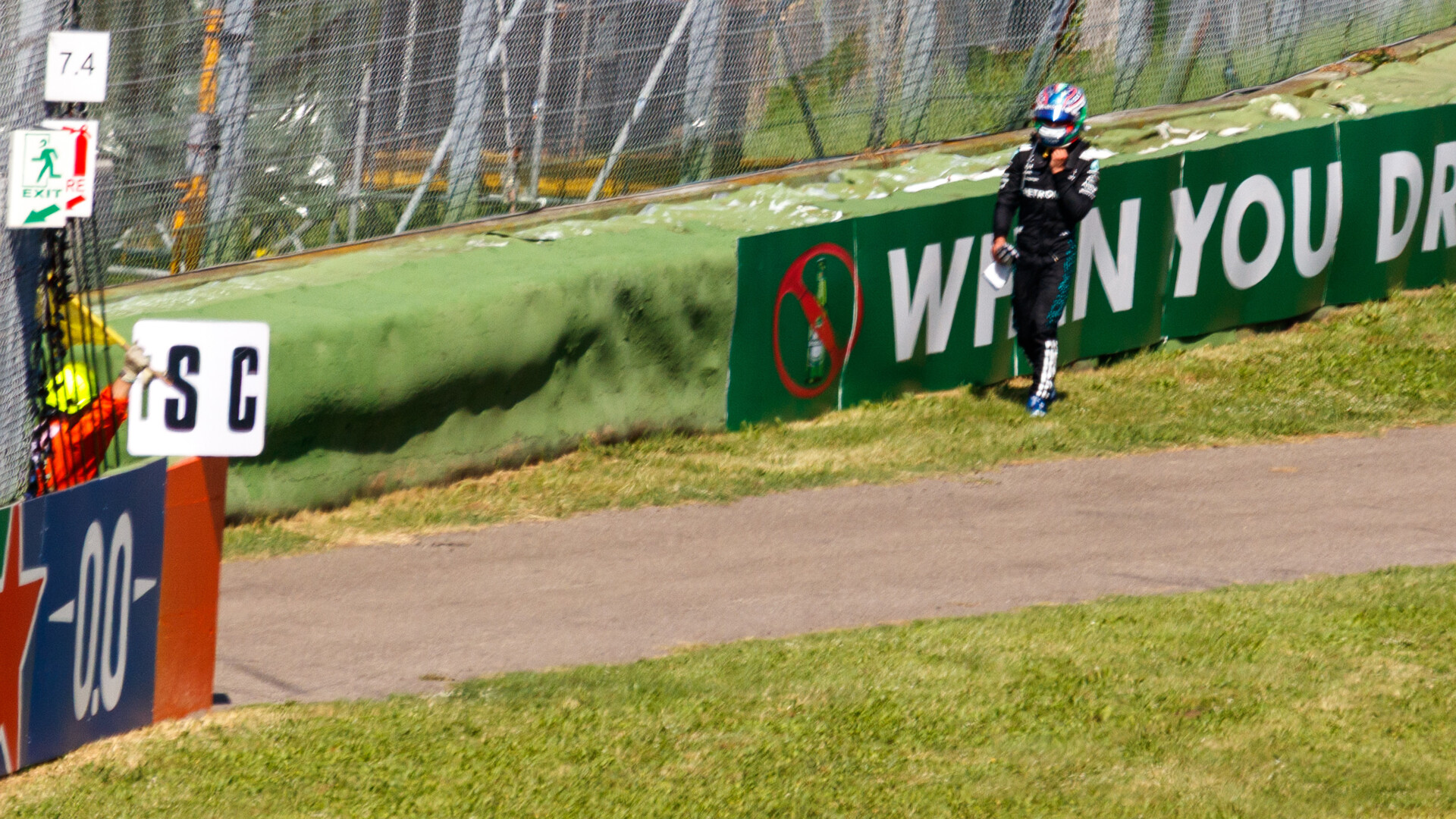 Kimi Antonelli walking along the barrier after retiring from the 2025 Emilia Romagna Grand Prix at Imola