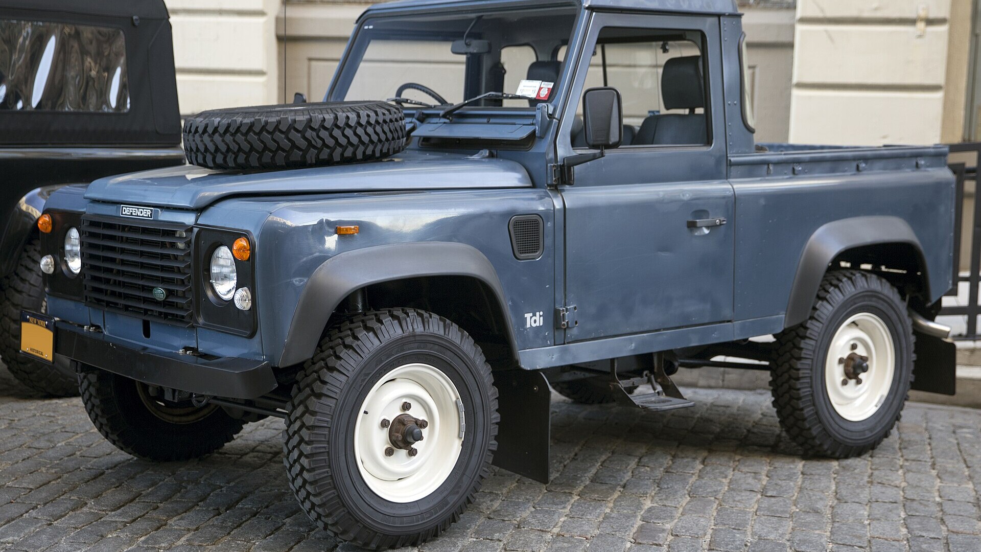 Blue 1991 Land Rover Defender 90 pickup, front three-quarter view, shown as a representative Defender