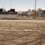 Circular black tire marks left by donuts on a paved road