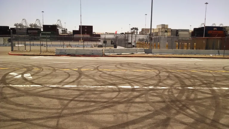 Circular black tire marks left by donuts on a paved road