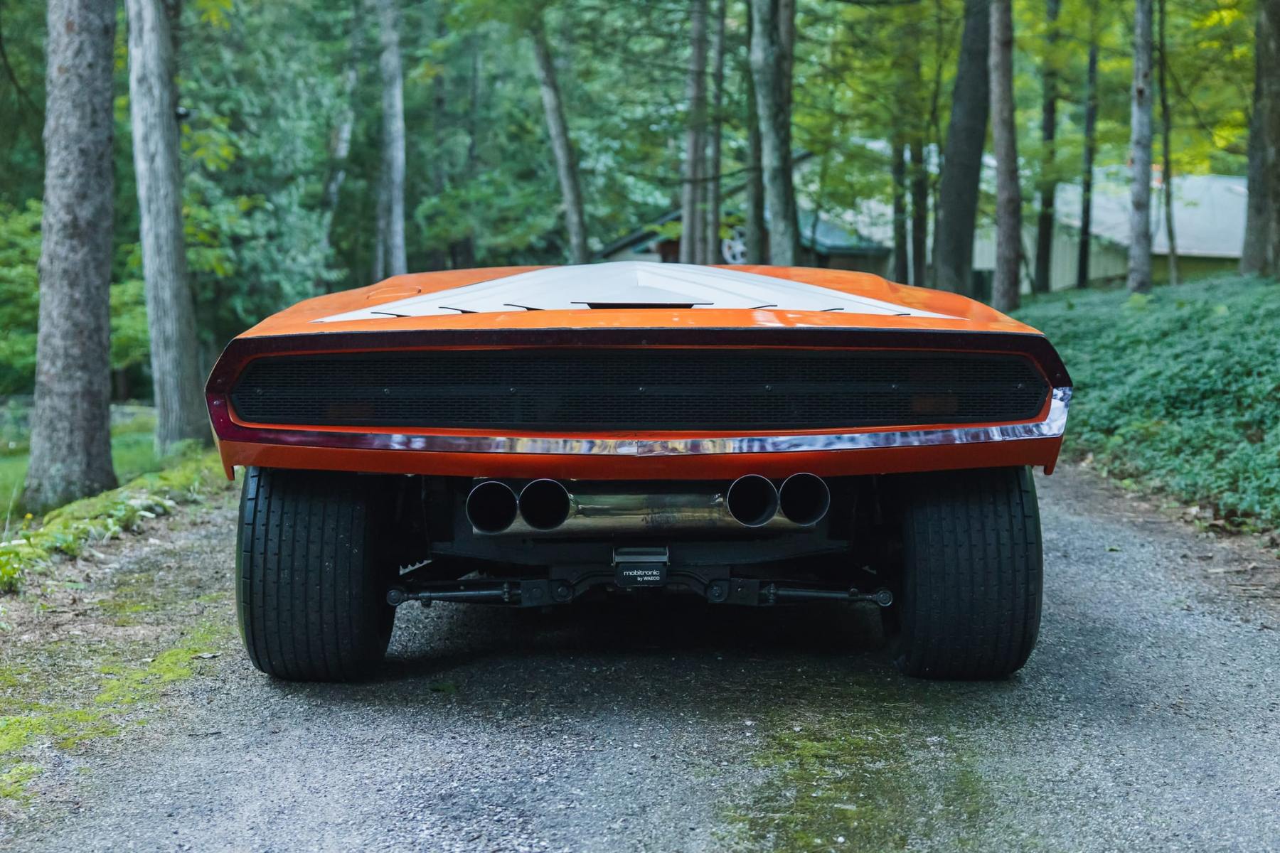 Rear view of the orange Stratos Zero re-creation showing tail lights and wide rear tires