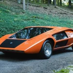 Orange Stratos Zero re-creation from Moonwalker, front three-quarter view on a gravel drive