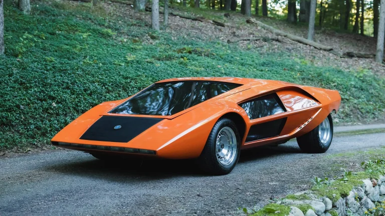 Orange Stratos Zero re-creation from Moonwalker, front three-quarter view on a gravel drive
