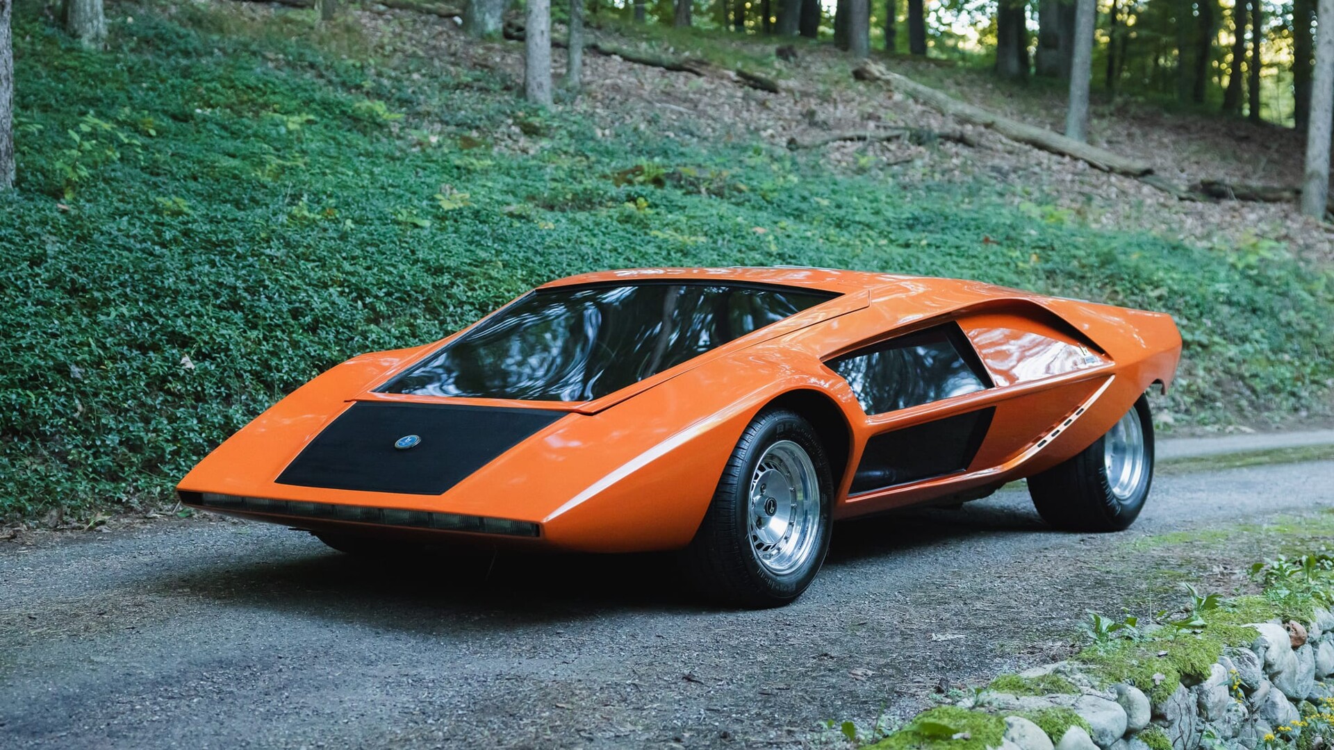 Orange Stratos Zero re-creation from Moonwalker, front three-quarter view on a gravel drive