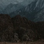 White truck driving on dirt road towards mountains