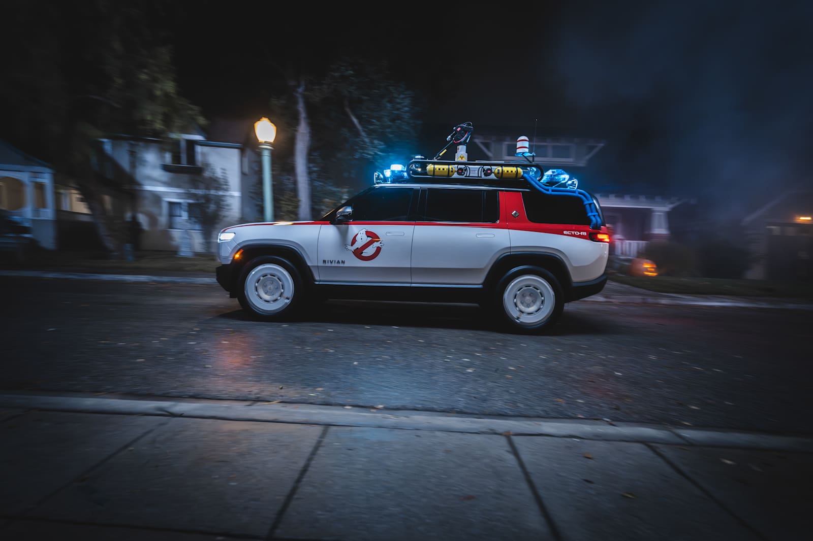 Rivian Ecto-R1 show car in white with red stripe, No-Ghost logo and roof-mounted lights