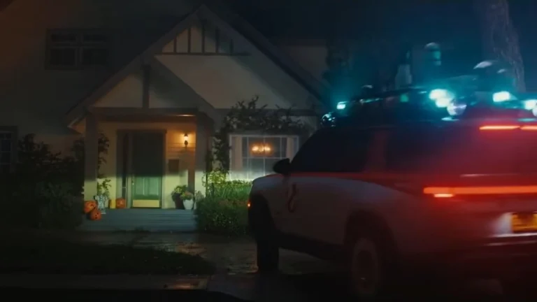 Ecto-R1 Rivian with roof lights parked outside a suburban house at night in Rivian's Ghostbusters spot