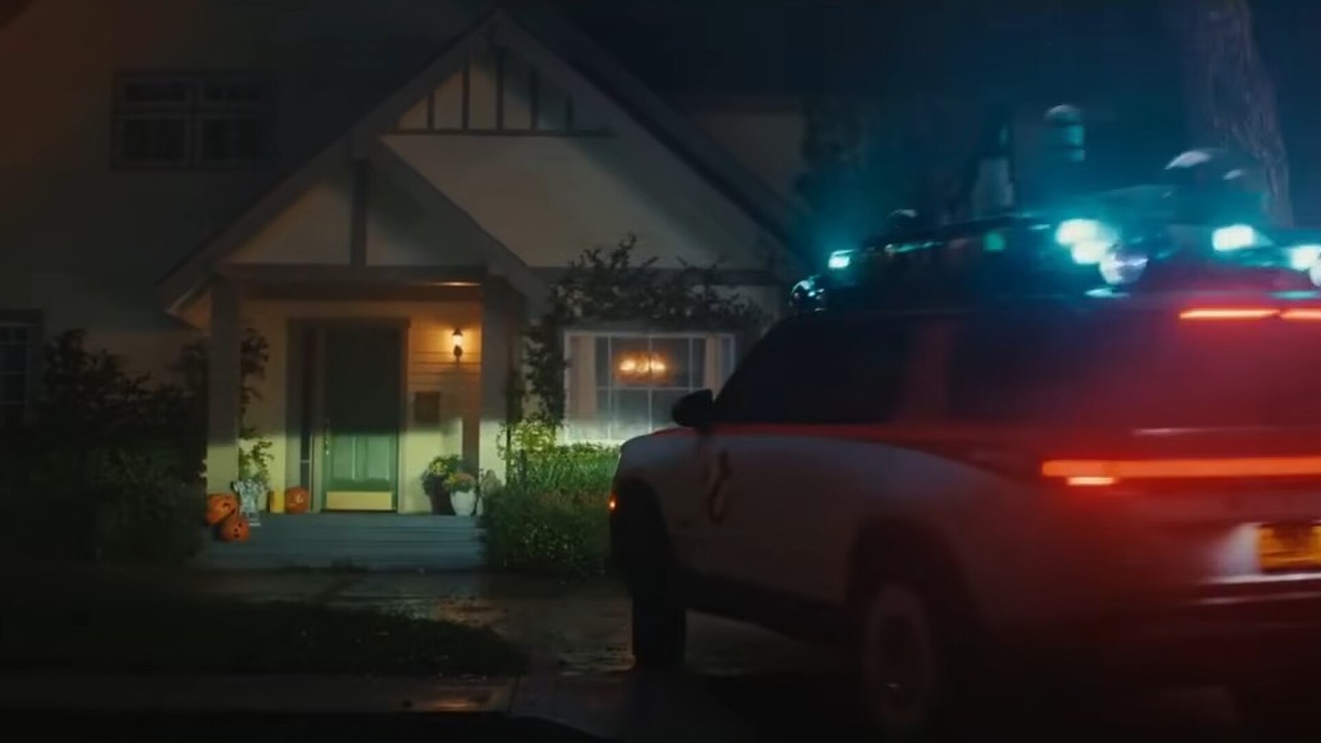Ecto-R1 Rivian with roof lights parked outside a suburban house at night in Rivian's Ghostbusters spot