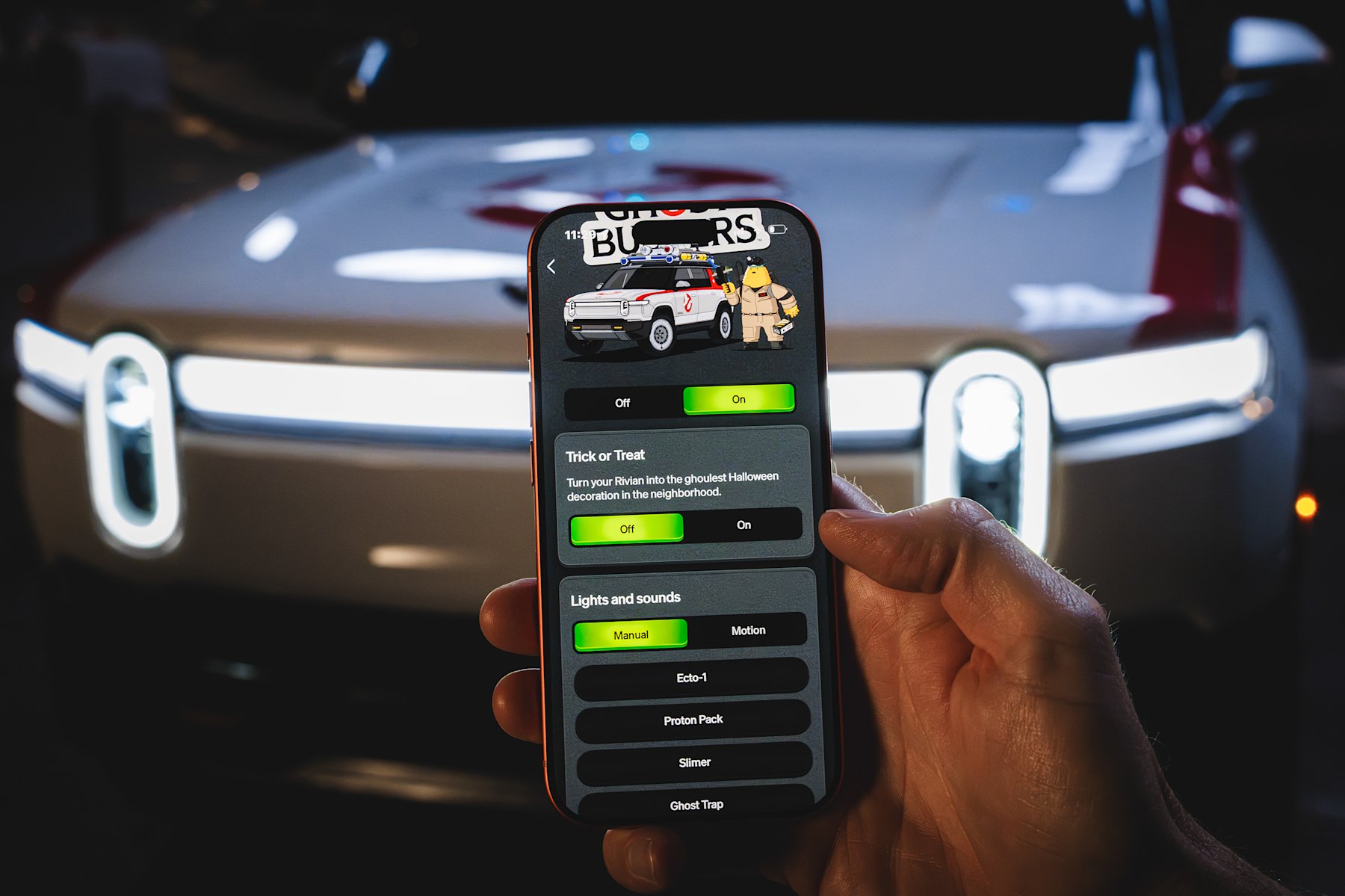 Rivian mobile app showing Ghostbusters Halloween Mode controls in front of an R1