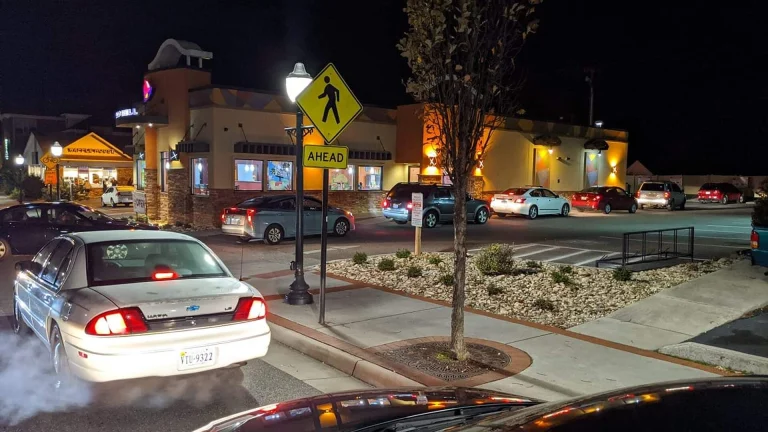 Cars lined up at a Taco Bell drive-thru at night