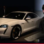 Tom Holland beside a white Porsche Taycan Turbo S
