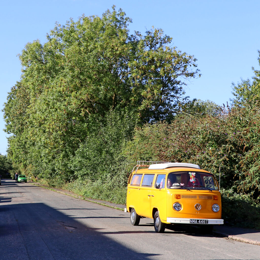 Yellow Volkswagen T2b Kombi on a tree-lined road in Staffordshire (representative image)